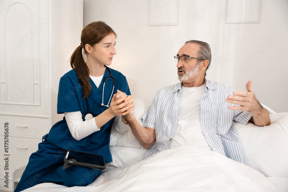 Fototapeta premium Young female nurse supporting senior male patient in bed during home care visit. Ideal for healthcare, elderly support, nursing, recovery, medical assistance, and caregiving visuals.