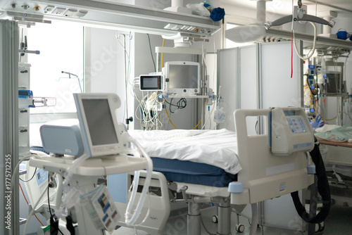 Modern intensive care unit with medical equipment and empty bed