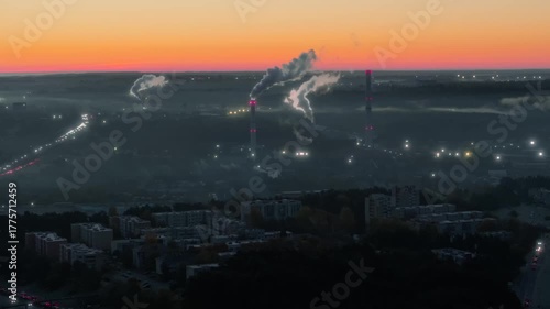 Factory industrial smokestacks producing smoke and fumes in early foggy morning, aerial view