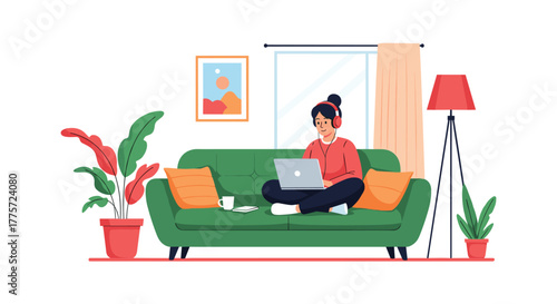 Productive woman in headphones happily working on her laptop while comfortably seated on a green sofa in a cozy home environment.