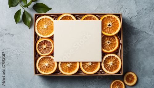 Eco paper gift box with dried orange slices sweet treat and blank card mockup.