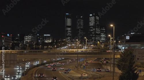 Evening view of Madrid’s M30 highway with car lights and the Cuatro Torres Business Area illuminated in the background