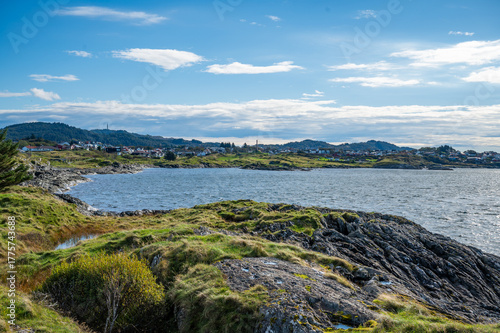 Kyststien, Haugesund, Norway, serene coastal landscape with a small town nestled among rolling hills, featuring a calm sea and lush greenery