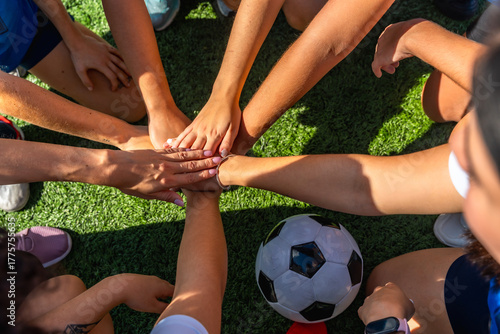 Canvas Print Soccer team hands joining forming huddle on grass
