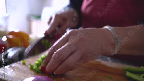 Mature woman hands dicing green pepper
