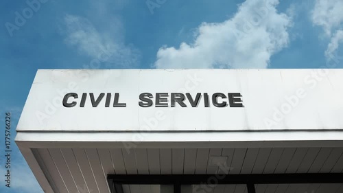 Civil Service word sign clearly displayed on the official government facade beneath a clear blue sky, signifying the administrative authority managing public sector employment and operations