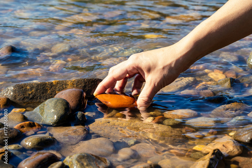 Hand touching the water of a clean and crystal clear river