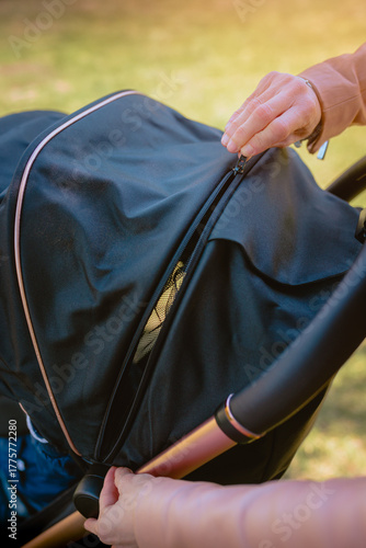 Mother adjusting stroller handle outdoors