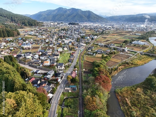 A city with a river running through it. The river is full of birds. The city is surrounded by mountains