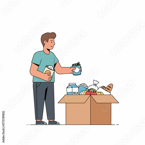 A young man puts canned food and groceries into a cardboard box for a charity food drive.