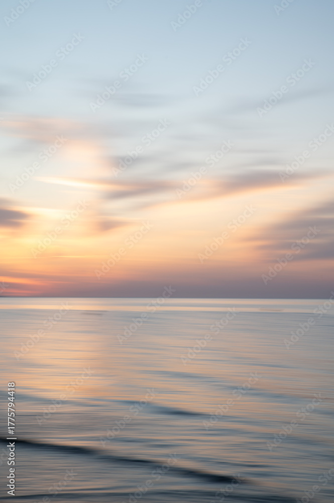 Fototapeta premium Artistic Blurred Background of Sea, Sky and clouds during a soft colours sunset. Copy space.