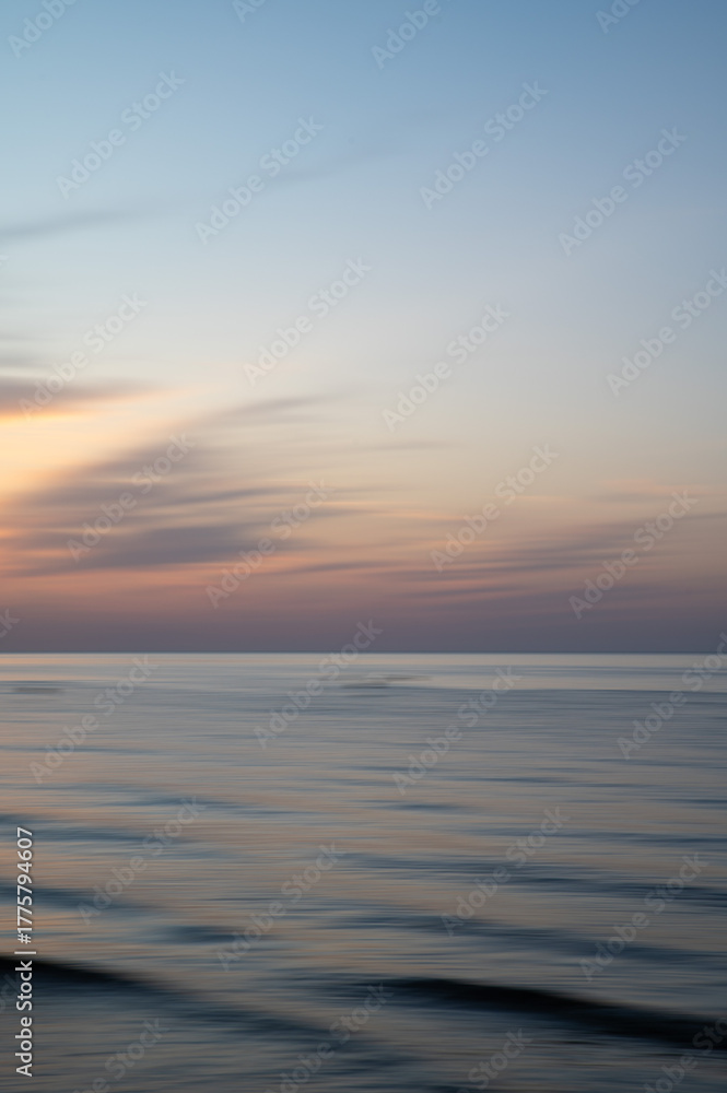 Obraz premium Artistic Blurred Background of Sea, Sky and clouds during a soft colours sunset. Copy space.