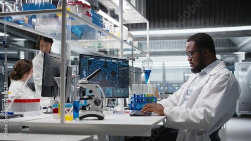 Scientist typing on keyboard, using computer program for DNA data analysis in laboratory driving treatment discovery. Expert using bioinformatics software on PC in sterile lab, camera A