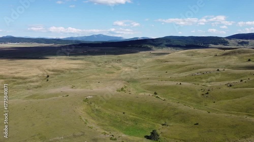 Drone footage of hills in a field.