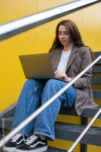 Freelancer Woman Sitting on Stairs with Laptop and Smartphone – Urban Digital Work Scene
