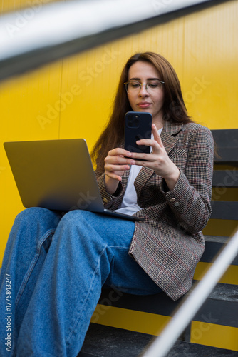 Freelancer Woman Sitting on Stairs with Laptop and Smartphone – Urban Digital Work Scene