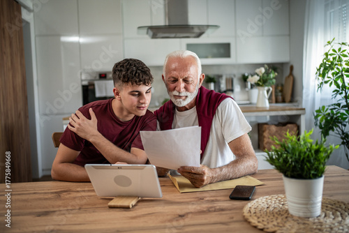 Grandfather grandson learning financial documents together at home