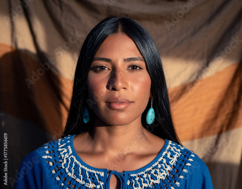 Latin woman in blue embroidered blouse illuminated by warm afternoon light