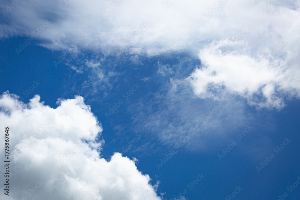 Obraz premium Blue sky with soft white clouds in close-up view, creating a calm and refreshing natural background