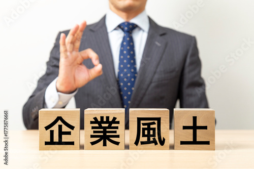「企業風土」と書かれたブロックとOKポーズをするビジネスマン