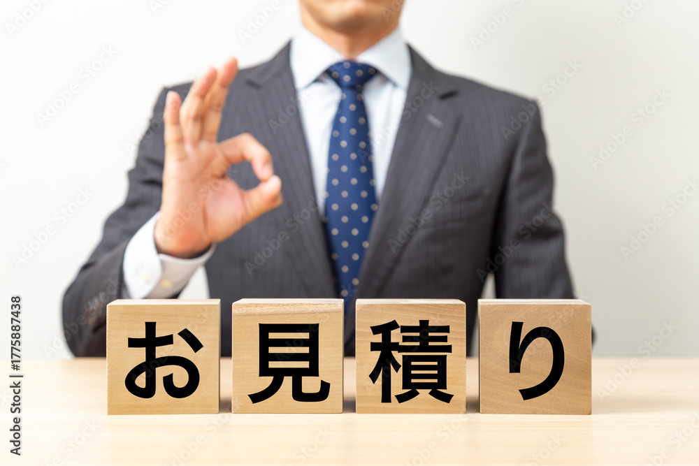 Obraz premium 「お見積り」と書かれたブロックとOKポーズをするビジネスマン