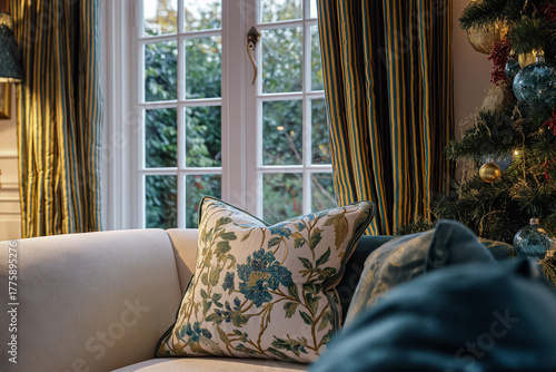 Cozy traditional living room decorated for Christmas holiday season with festive tree and decorative pillow on sofa