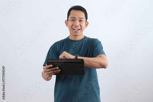 Young happy Asian man using digital tablet on white background