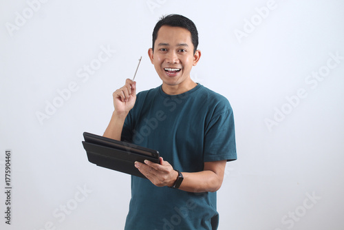 Happy Asian man with tablet and stylus having a creative idea.