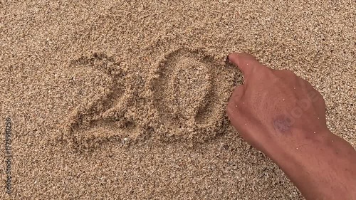 The number 2025 in the beach sand. The concept of change to the new year 2026.