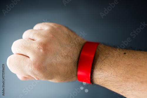 Close up of a red paper event bracelet on a male wrist, mockup template for an event.