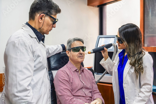 Derma clinic professionals doing cosmetic laser skin treatment