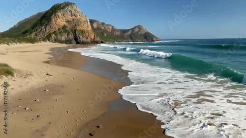overhead shot of a prominent coastal headland adjacent to a sandy