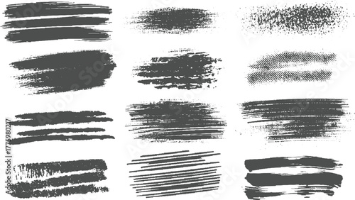 Collection of twelve dark grey textured brush stroke and splatter graphic elements on white background