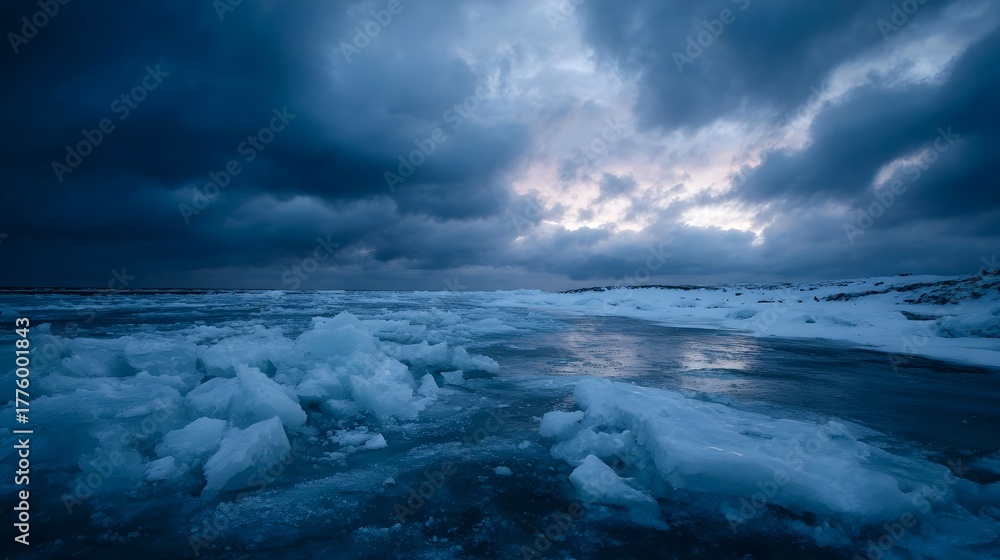 Obraz premium A dramatic frozen landscape at dusk with fractured ice under a stormy cloudy sky