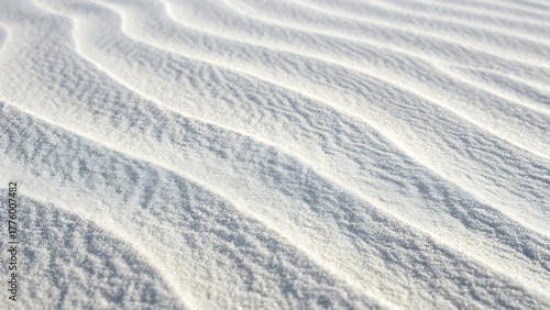 Close up of rippled white sand dunes with subtle blue and yellow reflections