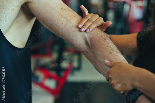 Woman massaging man's arm for muscle recovery and pain relief