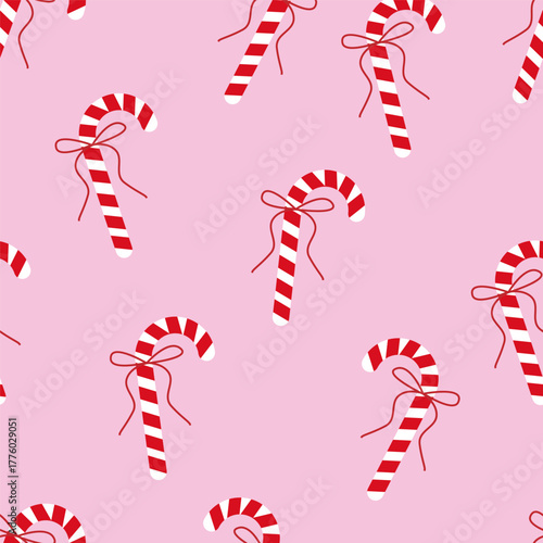 Candy cane seamless pattern with red bows on pink background, Christmas sweet decoration, flat vector illustration