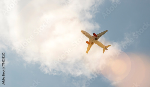 Airplane flying above clouds on a clear day with blue sky