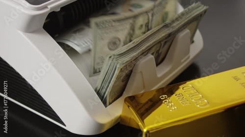 Money counting machine. Dollars in motion. Gold bars and US dollars. Money counting action. Banking operation with money and gold. Business concept with gold bar and money. Counting machine for