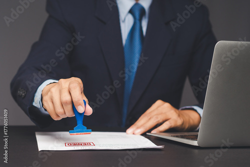 Businessman stamping denied on document for rejection or disapproval concept.