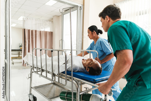 Medical staff work in collaboration as they transport a patient on a stretcher through a hospital corridor, highlighting urgent care, teamwork, monitoring, and the recovery process in healthcare.