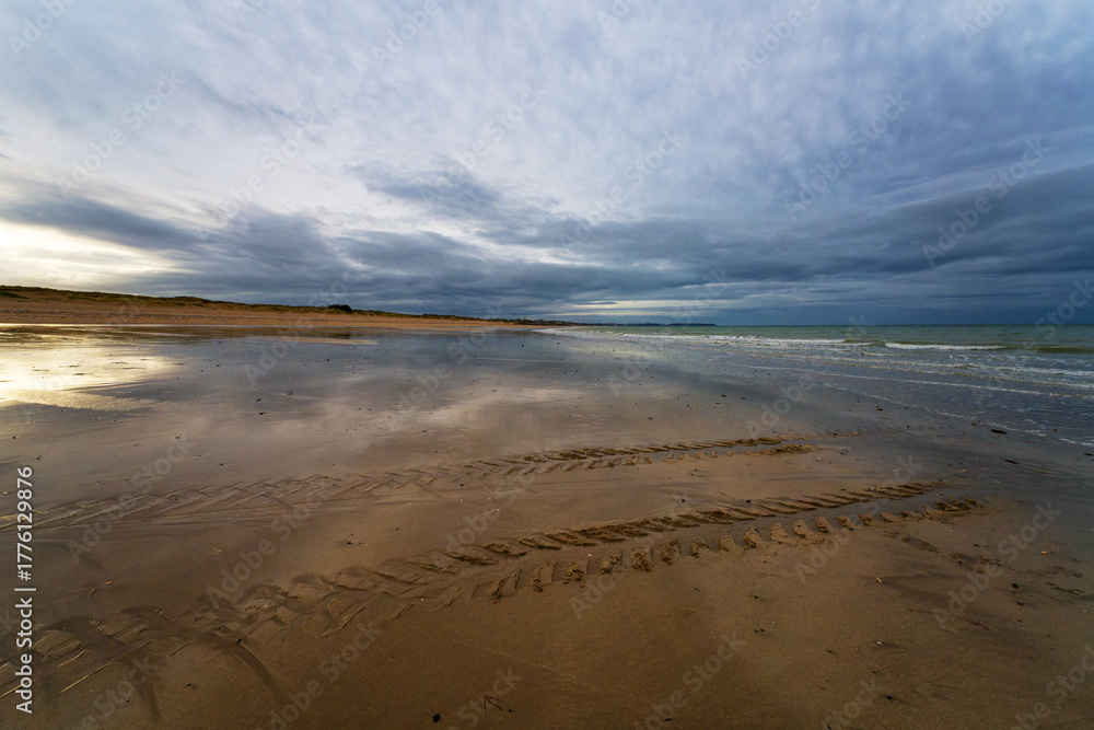 Obraz premium Tractor tracks on the beach of Bricqueville-sur-Mer village in Normandy region