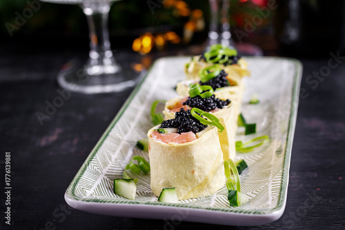 Canapes appetizer with salmon and black caviar on the Christmas table. Canapes with fish and caviar.