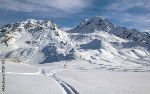 trace of ski touring in the freshly fallen snow on the ski slopes with snowy peak mountain background