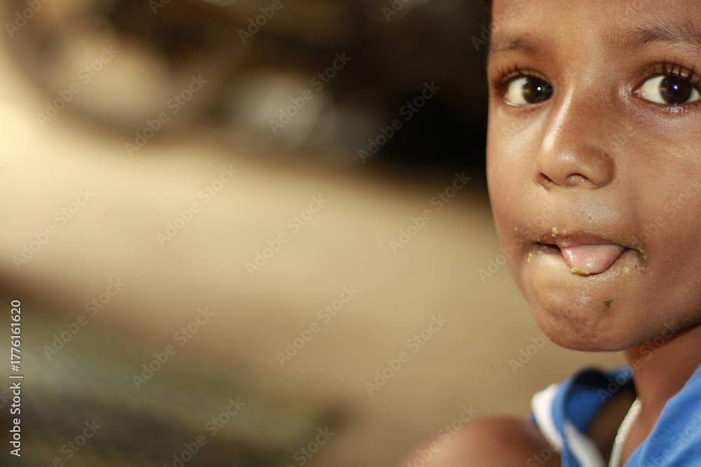 Φωτογραφία Close-up view of a young child eating homemade food, with small bits of food around the mouth,  innocence of childhood mealtime and the emotional bond of being lovingly fed by a caring hand