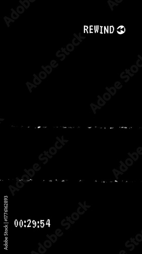 VHS video tape rewind overlay with distorted and scratches effect and timecode on black background. 4K Video.