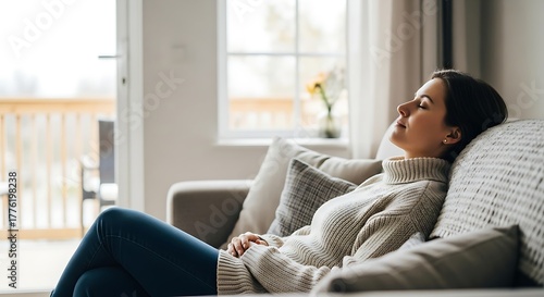 Young woman relaxing on sofa at home in comfortable clothes