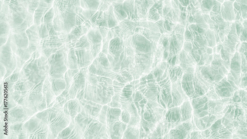A background of clear water over a sandy bottom. Shallow water with white sand. Gentle ripples on the surface. Glittering reflections on the sea.