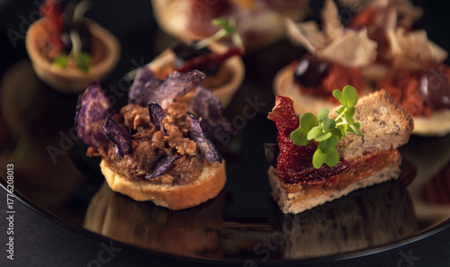 Close-up gourmet toast with purple chips and meat spread