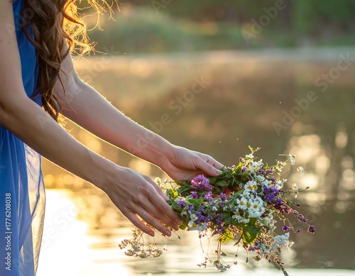A person, by a lake, holds a floral crown in golden sunlight